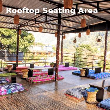 Rooftop seating area at Jungle Lore Resort with cushions and mountain view