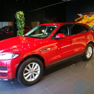 Raudonas „Jaguar F-Pace“ automobilių salone
