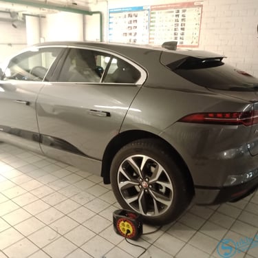 Juodas automobilis, stovintis prie namo.