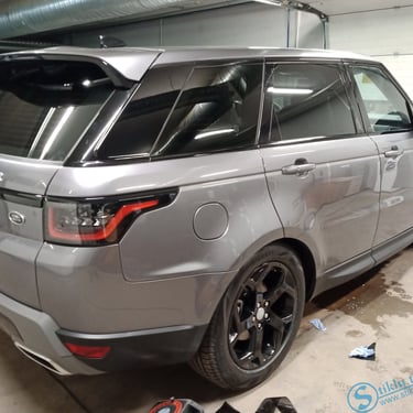 Pilkas Range Rover Sport su tamsintais langais garaže.