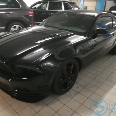 Juodas automobilis su tamsintais langais
