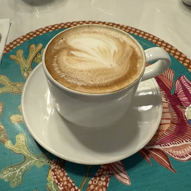 Cappuccino in a white mug with saucer at an Italian cafe