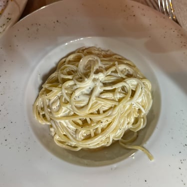 Cacio e pepe pasta served in a white bowl