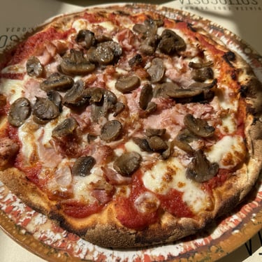 Sausage and salami pizza with pepperoni slices at an Italian restaurant