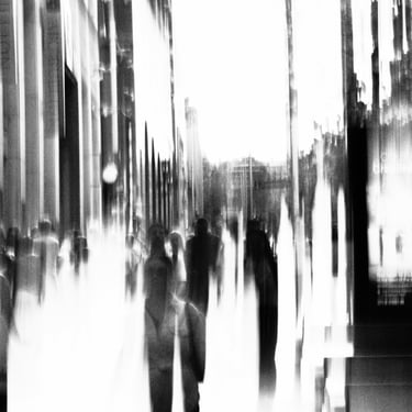 People walking in an urban setting, suggesting motion and activity. The scene conveys a sense of hustle and bustle.