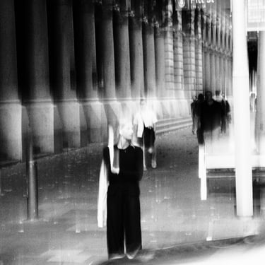 Image of people walking past a grand building. The scene is dreamy and surreal, evoking a sense of motion and mystery.