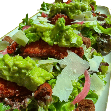 Salade César revisitée, avec poulet pané, crème d'avocat, tomats séchées, croutons de pain, pickles d'oignons, parmesan