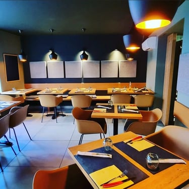 Salle de restaurant italien à Schiltigheim avec des tables dressées, des chaises confortables