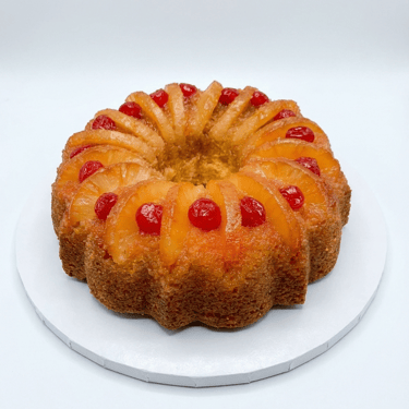 Golden rum bundt cake topped with pineapple rings and cherries