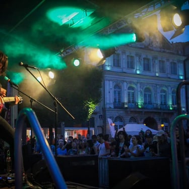 Dimitri jouant de la guitare sur scène face au publique de douai lors de la fête de la musique 2023 sur la place d'armes