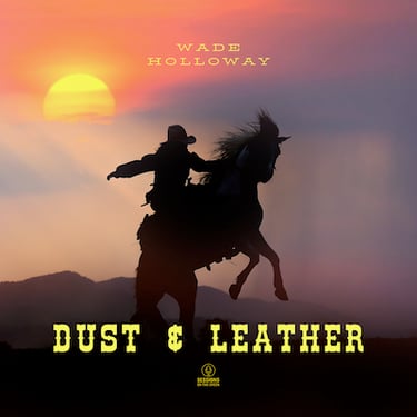 Cowboy riding in desert at sunset