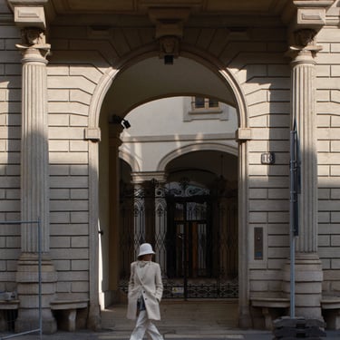 foto street di una donna vestita di bianco che cammina sul marciapiede