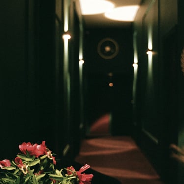 eine Vase mit Blumen in einem Flur eines Hotels