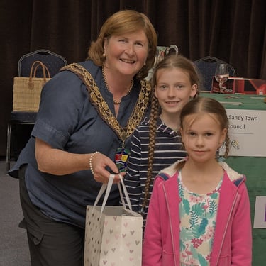 Cllr Joanna Hewitt receiving a gift from Isabella & Bethany Evans after presenting the Awards at the 2024 Sandy Show