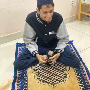 "Group of people posing together outdoors, smiling and standing on a grassy field with trees in the background."
