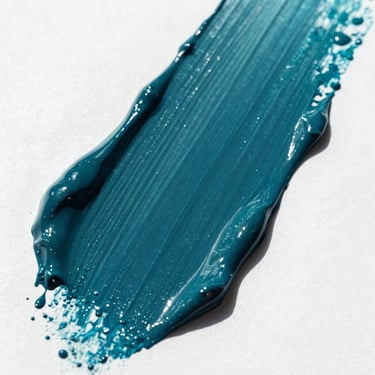 Close-up of deep teal paint brushstroke on a crisp white surface, showcasing wet pigment texture, bright natural light, 35mm