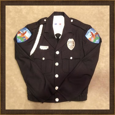 Official Tooele City black police uniform jacket with department patches and silver badge.