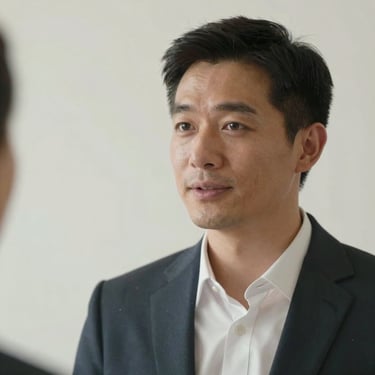 A portrait of a male employer in a professional setting, looking engaged and friendly, with a clean background in soft pearl white tones.