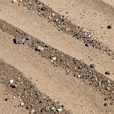 Macro photography of fine and coarse classified sand, high-contrast mineral textures, harsh desert light, sharp focus