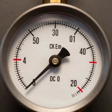 Extreme close-up of an industrial pressure gauge dial, clinical studio lighting, the needle resting precisely at a red-tagged tolerance threshold, matte charcoal background, no warm tones, forensic framing