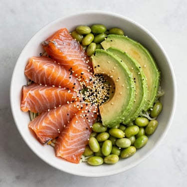 Overhead shot of a colorful poke bowl with salmon, avocado, edamame and sesame seeds in a white bowl, bright natural light