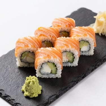 Overhead close-up of sushi rolls arranged neatly on a dark slate plate with wasabi and ginger, clean studio light, vivid colors