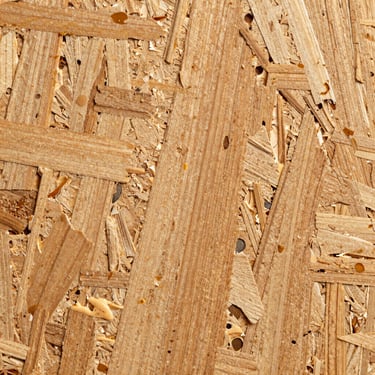 Macro shot of high-density particle board core, showcasing compressed wood fibers and uniform resin distribution.