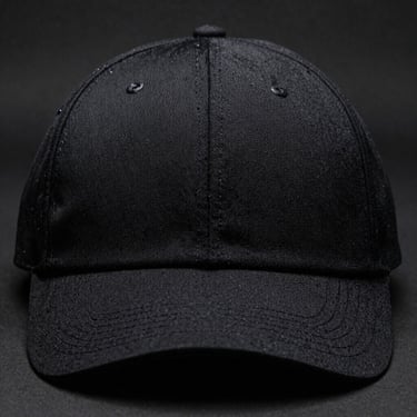 Front-facing product shot of a black Flexfit structured athletic cap, workshop side lighting, rich fabric texture, 50mm lens