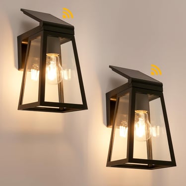 Outdoor solar light fixtures illuminating a backyard patio at night.