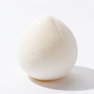 clean product shot of a facial cleansing sponge, bright high-key natural light, clean white background, sharp focus, 35mm