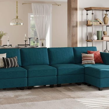 Modern teal blue sectional sofa with chaise lounge and throw pillows in a cozy living room.
