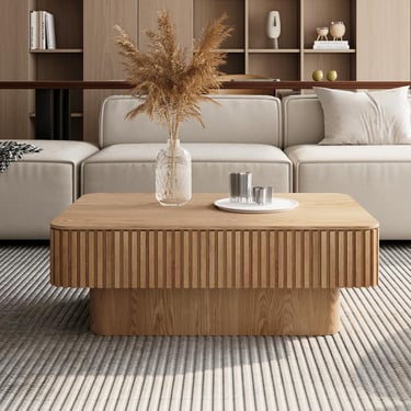 Modern fluted oak coffee table in a minimalist living room with a neutral sofa and pampas grass decor.