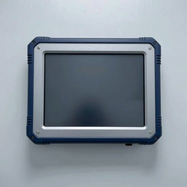 IP65 rated rugged touch monitor with thick rubberized borders, on a solid clinical light-gray metallic background