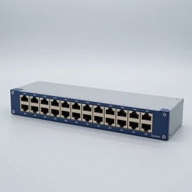 Heavy-duty industrial managed network switch with multiple ethernet ports, on a solid clinical light-gray metallic background