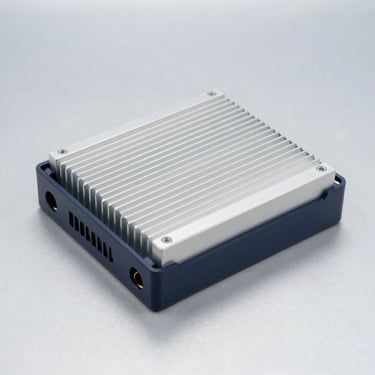 Fanless embedded DIN rail box PC with rugged aluminum heatsink fins, on a solid clinical light-gray metallic background