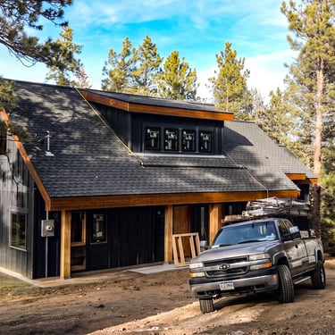Modern detached garage with dark siding and wood trim built by Elk Valley Contractors in Evergreen, Colorado.