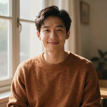 Warm editorial portrait of Marcus Chen in a cozy sweater, soft indoor window light, friendly expression, 35mm