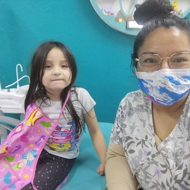Dentista con una paciente niña en consultorio dental