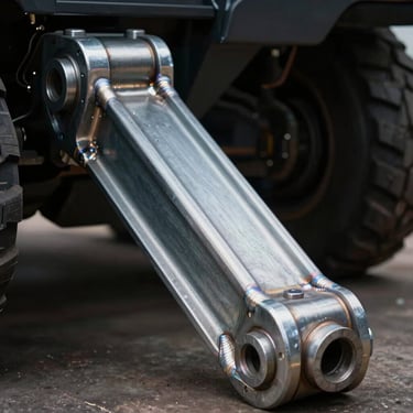 Close-up of a forged steel control arm for heavy vehicles, highlighting the precision welds and structural thickness, dark background.