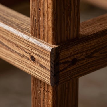 Macro shot of premium joint wood construction, showcasing the raw grain of dark treated timber, warm directional side lighting, tactile texture.