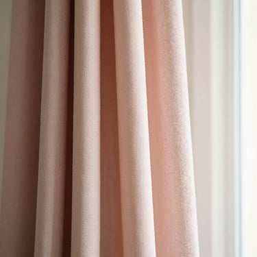 Soft drapes of a premium pastel pink scarf, showcasing delicate fabric texture and weave under warm window light