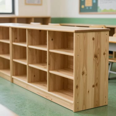 A row of modular wooden classroom units at a local school, featuring clean sand-colored wood and green surroundings.