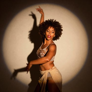 Portrait of a female Afro-Brazilian contemporary dancer, dramatic theatrical spotlight, shadows, expressive face