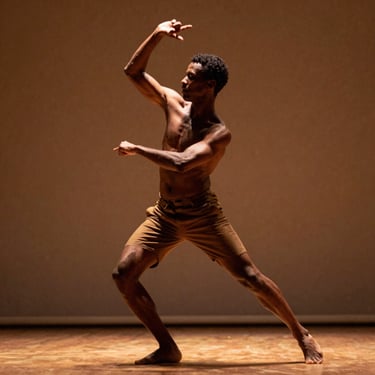 Expressive portrait of a male Afro-Brazilian dancer, dynamic mid-movement tension, warm side-lighting, earthy background