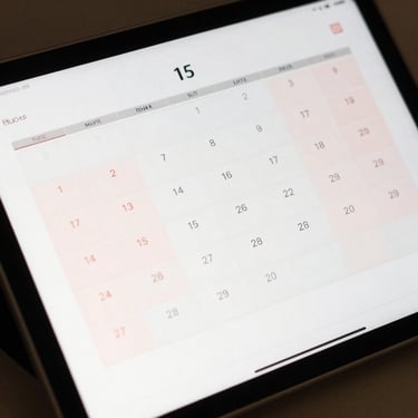 A clean digital calendar on a tablet showing a structured schedule with soft dusty pink highlights.