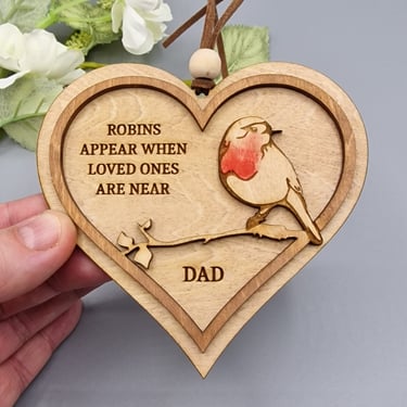 a person holding a wooden heart shaped plaque