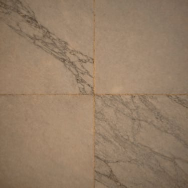 Close-up detail of honed Calacatta marble, soft golden hour light, desaturated warm tones, medium format film