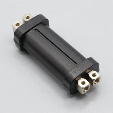 Crisp product shot of a black ignition coil pack, clean metallic connectors, studio lighting, gray background