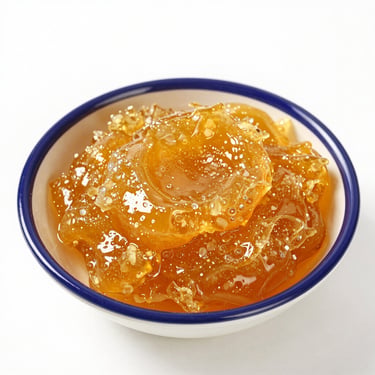 Close-up of rich golden farm ghee with granular texture, bright natural light, crisp white background