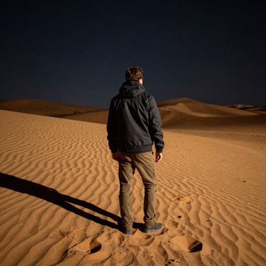 A candid portrait of a smiling traveler holding a camera against a sunset backdrop.